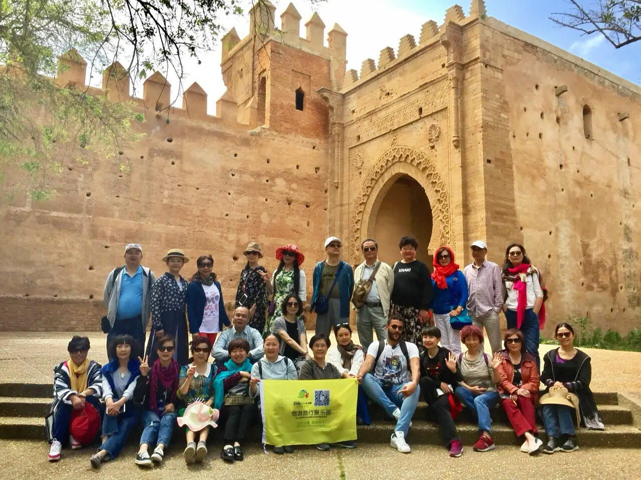 Reda Akrime in the middle of 25 Chinese tourists taking a group photo at Chellah in Rabat, Morocco