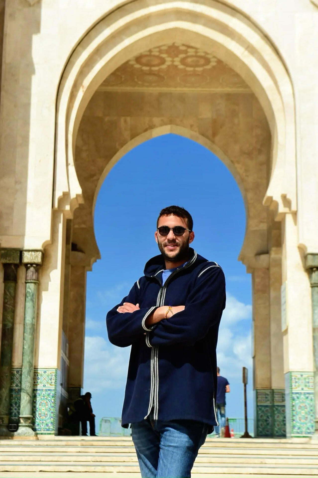 Reda Akrime in front of Hassan 2 Mosque in Morocco, wearing sunglasses